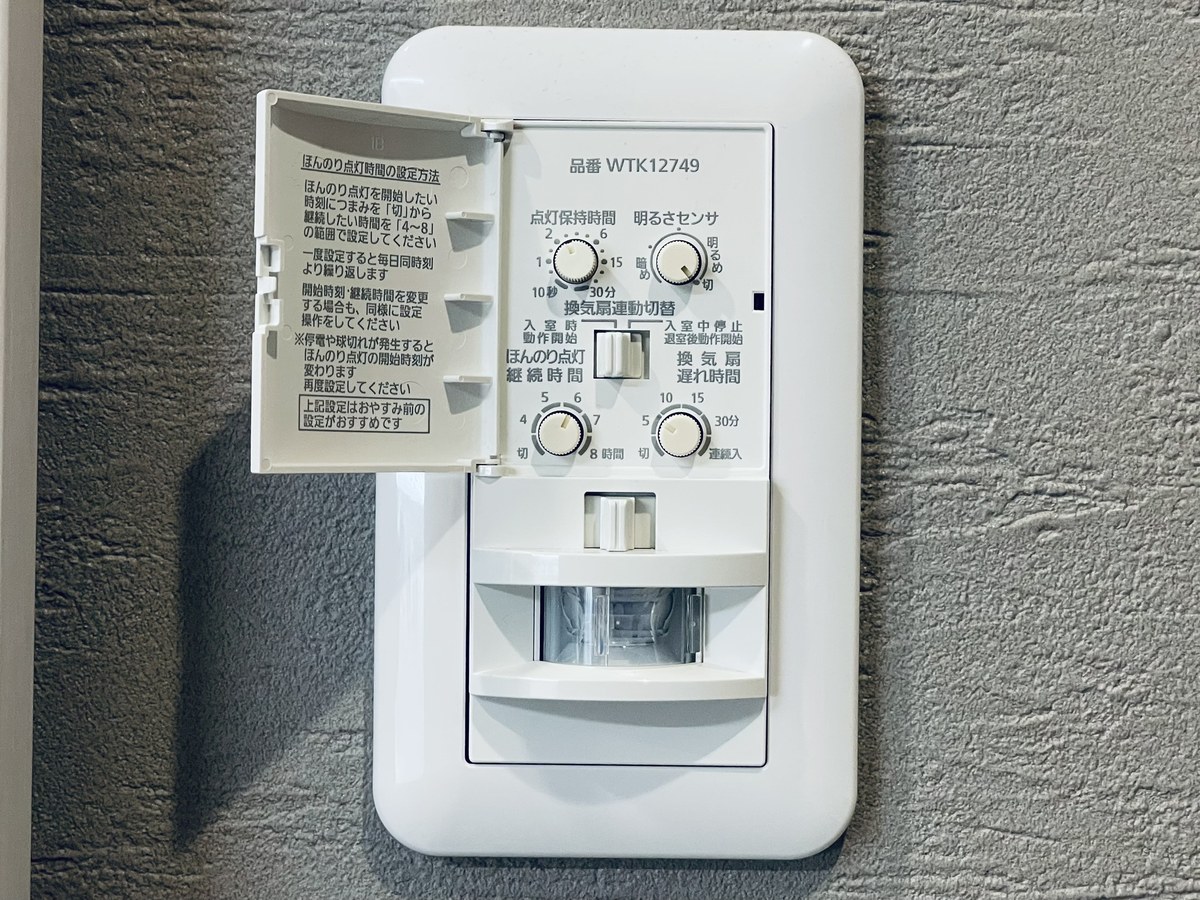 扉を開けたWTK12749W。上段に点灯保持時間と明るさセンサ、下段にほんのり点灯継続時間と換気扇遅れ時間のつまみが並ぶ